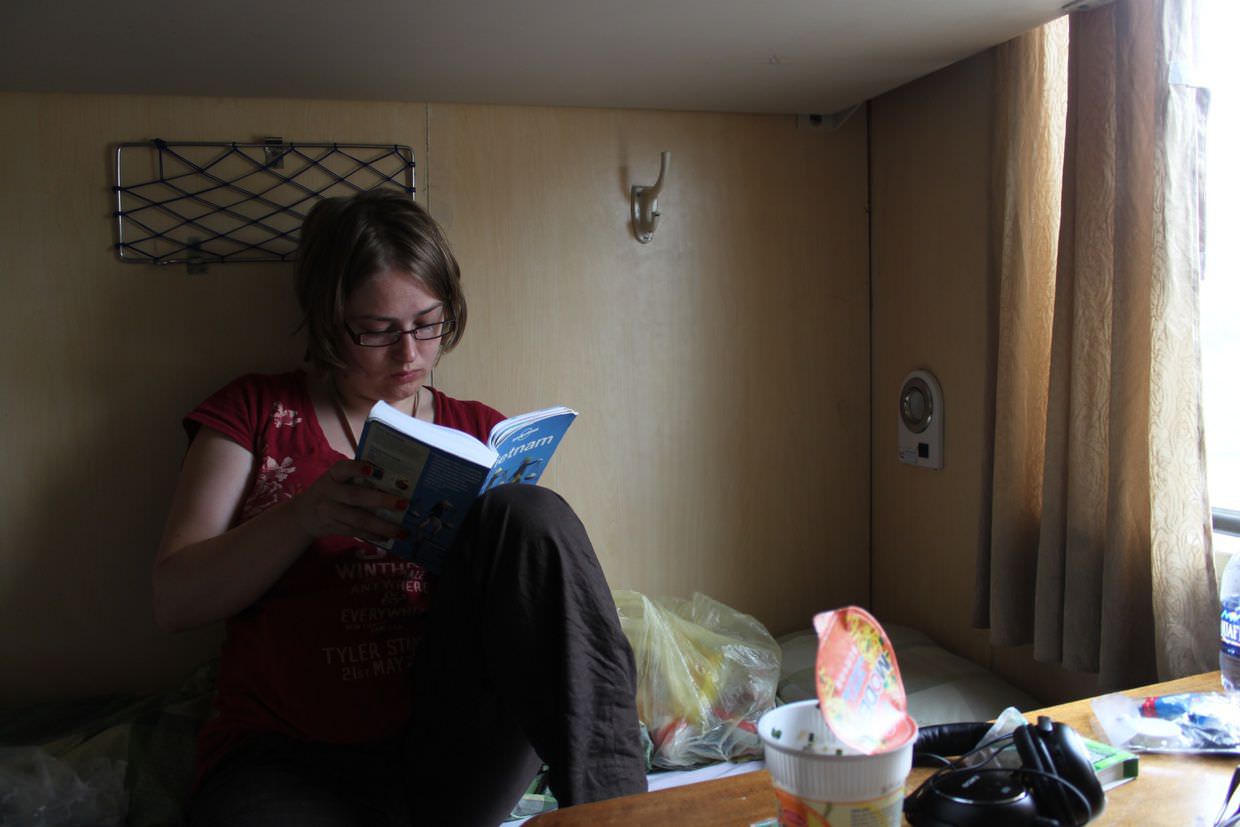 Samantha reading about Hanoi on the sleeper train