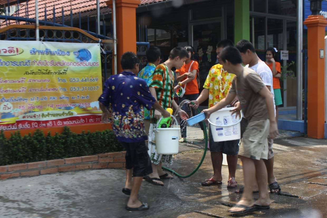 Teens with water filled buckets for soaking passers by, it’s almost Songkran