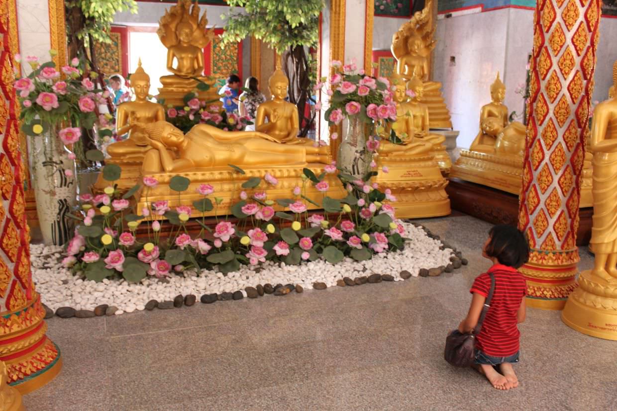 Girl praying inside Wat Chalong
